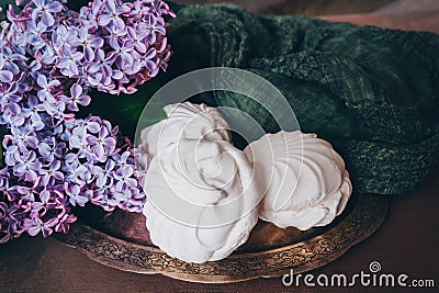 Zephyr sweet dessert on silver platter and spring flowers. Confectionery, sweetshop concept. Stock Photo