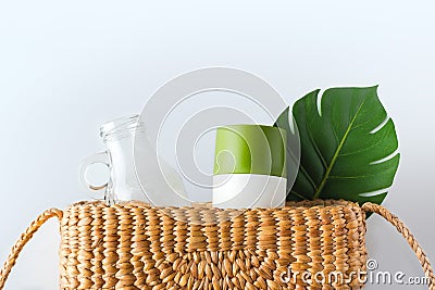 Zero waste concept.top view wicker bag with glass bottle and reusable cup with green leaf on white table.eco friendly for Stock Photo