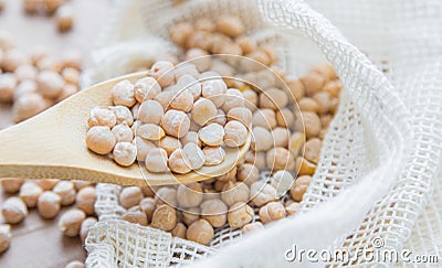 Zero waste . Shop assistant filling reusable bag with dried chickpeas in organic grocery stor. rejection of plastic, waste Stock Photo