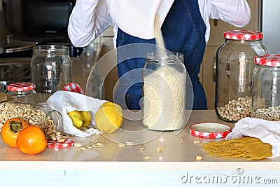 Young woman in kitchen with grocery shopping in bulk. Stock Photo