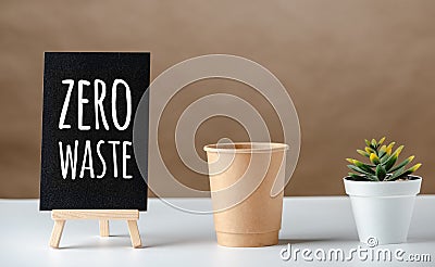 Zero waste word on blackboard with peper cup and green plant on white table and brown background.eco friendly concept Stock Photo