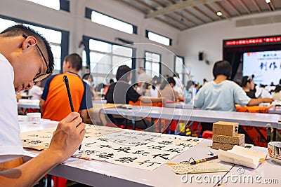 students in calligraphy competition using Chinese brushes at horizontal composition Editorial Stock Photo