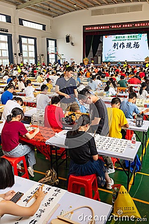 students in calligraphy competition using Chinese brushes at vertical composition Editorial Stock Photo