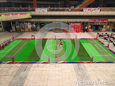 boy playing soccer inside a shopping mall in a indoor soccer field. Editorial Stock Photo