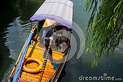 ZHOUZHUANG, CHINA: Helmsman driving the boat passing through canals Stock Photo