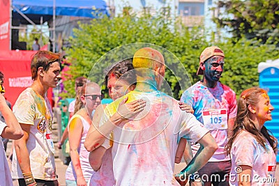 Zhytomyr, Ukraine - June 25, 2016: happy people crowd partying under colorful powder cloud run competition at holi fest Editorial Stock Photo