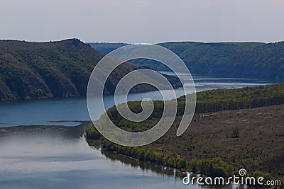 Zigzag river flows between summer valleys. Dniester river Stock Photo