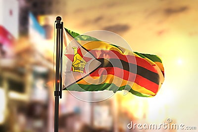 Zimbabwe Flag Against City Blurred Background At Sunrise Backlight Stock Photo