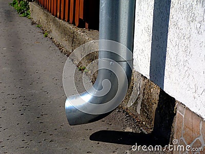 Zink downspout rain water leader detail at sidewalk level Stock Photo