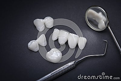 Zircon dentures and Dental tools on a dark background - Ceramic veneers - lumineers Stock Photo