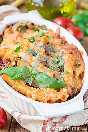 Ziti bolognese in baking dish. Pasta casserole with minced meat, tomato sauce and cheese, vertical Stock Photo