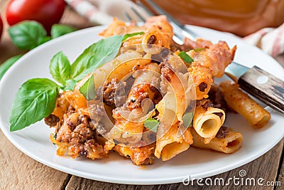 Ziti bolognese on white plate, pasta casserole with minced meat, tomato sauce and cheese, horizontal Stock Photo