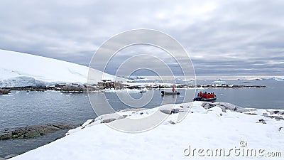 Zodiacs approaching snow covered slopes in Antarctica Stock Photo
