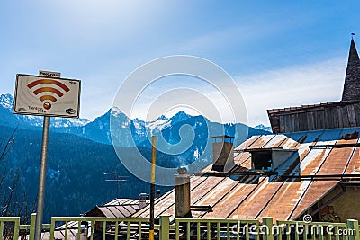 Free Wi-Fi zone sign, tin, rusted roof and snow-capped mountains in the background. Stock Photo