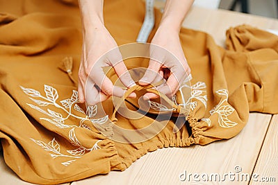 Zoomed in image of seamstress hands lacing a dress Stock Photo