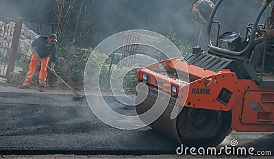 Workers at work to redo the road surface Editorial Stock Photo