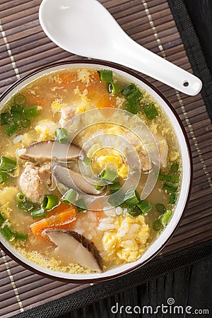 Zosui is a comforting Japanese rice soup cooked in a savory dashi broth with vegetables, eggs, mushrooms, and chicken close-up in Stock Photo