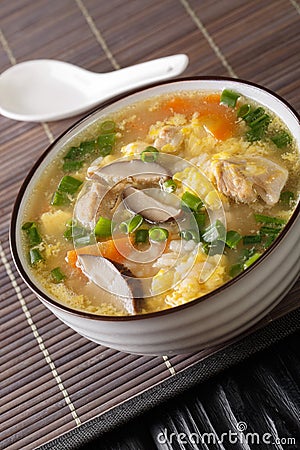 Zosui is a comforting Japanese rice soup cooked in a savory dashi broth with vegetables, eggs, mushrooms, and chicken close-up in Stock Photo