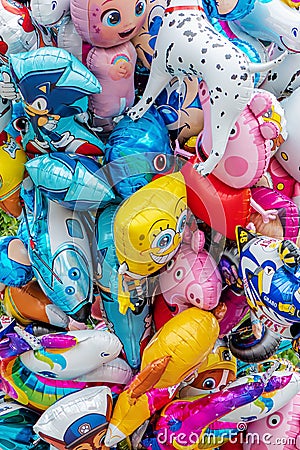 Bunch of helium balloons with various famous cartoon characters for children on street market Editorial Stock Photo