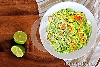 Zucchini noodle dish with lime on wood background Stock Photo