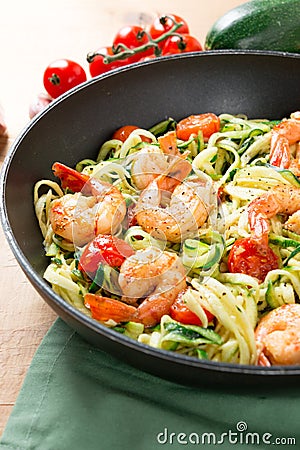 Zucchini noodles sauteed with cherry tomato and prawns in a pan Stock Photo