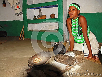 Zulu woman cooking maize meal at tribal house,Lesedi Village Editorial Stock Photo