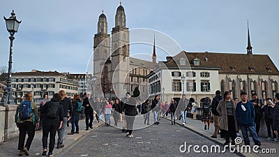 ZURICH, SWITZERLAND - JANUARY 1, 2023. The Grossmunster Cathedral as seen from crowded Munsterbrucke bridge Editorial Stock Photo