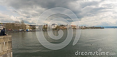 Zurich, ZH / Switzerland - April 8, 2019: tourist admires the cityscape and lakeshore view of Zurich during the hustle and bustle Editorial Stock Photo