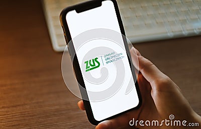 ZUS logo on the smartphone screen in hand Editorial Stock Photo