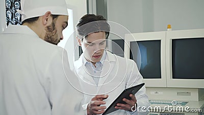 Zwei Doktoren, die an mri Anzeige im Krankenhauszimmer raten 4K stock video footage Zwei Doktoren, die an mri Anzeige im Krankenhauszimmer raten 4K stock video footage