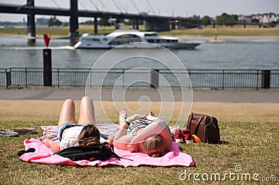 Two women lie in a meadow on the Rhine in Duesseldorf, Germany, Europe Editorial Stock Photo