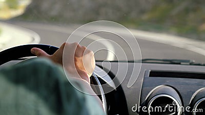 Équipez la main du ` s sur le volant conduisant une voiture dans la longue route le long des montagnes dans le mouvement lent 384 Équipez la main du ` s sur le volant conduisant une voiture dans la longue route le long des montagnes dans le mouvement lent 384