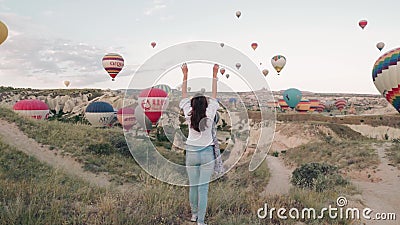Νέα ανατολή γυναικών που μένει στο βουνό με ballons ζεστού αέρα γύρω Σταθερός πυροβολισμός εκκέντρων Νέα ανατολή γυναικών που μένει στο βουνό με ballons ζεστού αέρα γύρω Σταθερός πυροβολισμός εκκέντρων