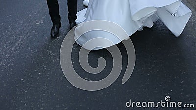 Το άτομο και η νύφη του τρέχουν κατά μήκος του δρόμου μέσω των ψηλών δέντρων κρατώντας τα χέρια φιλμ μικρού μήκους Το άτομο και η νύφη του τρέχουν κατά μήκος του δρόμου μέσω των ψηλών δέντρων κρατώντας τα χέρια φιλμ μικρού μήκους