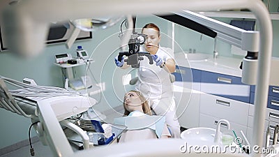 Żeński dentysta z stomatologicznymi narzędziami - mikroskopu, lustra i sondy częstowania cierpliwi zęby przy stomatologicznym kli zdjęcie wideo Żeński dentysta z stomatologicznymi narzędziami - mikroskopu, lustra i sondy częstowania cierpliwi zęby przy stomatologicznym kli zdjęcie wideo