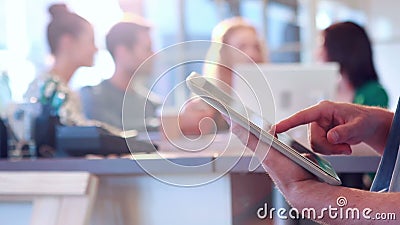 Επιχειρηματίας που χρησιμοποιεί τον υπολογιστή ταμπλετών με τους συναδέλφους του πίσω από τον Επιχειρηματίας που χρησιμοποιεί τον υπολογιστή ταμπλετών με τους συναδέλφους του πίσω από τον