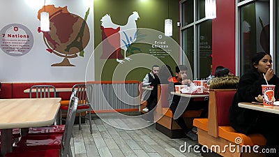 Η κίνηση των ανθρώπων απολαμβάνει ένα γεύμα μέσα στο εστιατόριο με κοτόπουλο Popeyes Η κίνηση των ανθρώπων απολαμβάνει ένα γεύμα μέσα στο εστιατόριο με κοτόπουλο Popeyes