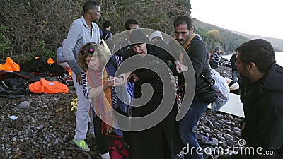 ΛΈΣΒΟΣ, ΕΛΛΑΔΑ - 5 ΝΟΕΜΒΡΊΟΥ 2015: Οι εθελοντές βοηθούν τη γυναίκα πρόσφυγα για να πάνε στην ακτή ΛΈΣΒΟΣ, ΕΛΛΑΔΑ - 5 ΝΟΕΜΒΡΊΟΥ 2015: Οι εθελοντές βοηθούν τη γυναίκα πρόσφυγα για να πάνε στην ακτή