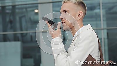 Νέος επιχειρηματίας που χρησιμοποιεί την επιχείρηση app στο smartphone που περπατά στην πόλη κοντά στον αερολιμένα Στέλνει το μήν απόθεμα βίντεο Νέος επιχειρηματίας που χρησιμοποιεί την επιχείρηση app στο smartphone που περπατά στην πόλη κοντά στον αερολιμένα Στέλνει το μήν απόθεμα βίντεο
