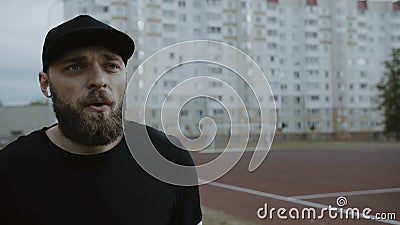 Νεαρός άνδρας αθλητής με κίνητρα που ετοιμάζεται να τρέξει στο στίβο, θέτοντας χρονόμετρο σε έξυπνη παρακολούθηση και ξεκινώντας απόθεμα βίντεο Νεαρός άνδρας αθλητής με κίνητρα που ετοιμάζεται να τρέξει στο στίβο, θέτοντας χρονόμετρο σε έξυπνη παρακολούθηση και ξεκινώντας απόθεμα βίντεο
