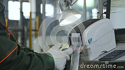 Ο εργαζόμενος άποψης πίσω πλευρών κινηματογραφήσεων σε πρώτο πλάνο ανιχνεύει τον εκτυπωτή γραμμωτών κωδίκων Ο εργαζόμενος άποψης πίσω πλευρών κινηματογραφήσεων σε πρώτο πλάνο ανιχνεύει τον εκτυπωτή γραμμωτών κωδίκων