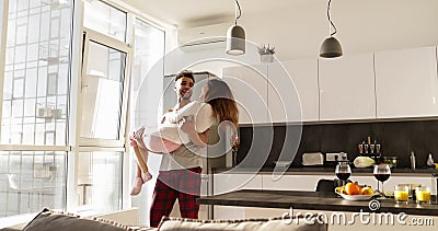 Ο ευτυχής χαμογελώντας ισπανικός άνδρας φέρνει την ασιατική γυναίκα, νέο ρομαντικό ζεύγος που γυρίζει Aroud μαζί στην κουζίνα Ο ευτυχής χαμογελώντας ισπανικός άνδρας φέρνει την ασιατική γυναίκα, νέο ρομαντικό ζεύγος που γυρίζει Aroud μαζί στην κουζίνα