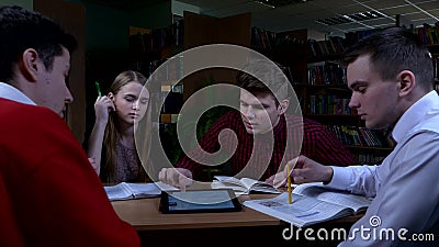 Ομάδα σπουδαστών που κάθονται σε έναν πίνακα σε μια βιβλιοθήκη απόθεμα βίντεο Ομάδα σπουδαστών που κάθονται σε έναν πίνακα σε μια βιβλιοθήκη απόθεμα βίντεο