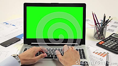Χέρι ατόμων στο πληκτρολόγιο lap-top με την πράσινη οθόνη Χέρι ατόμων στο πληκτρολόγιο lap-top με την πράσινη οθόνη