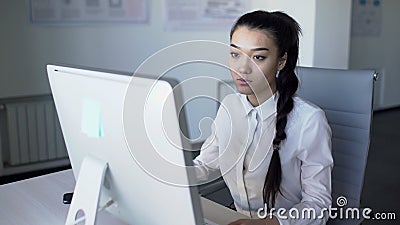 Азиатская бизнес-леди сидит на столе и начинает работать на компьютере сток-видео Азиатская бизнес-леди сидит на столе и начинает работать на компьютере сток-видео