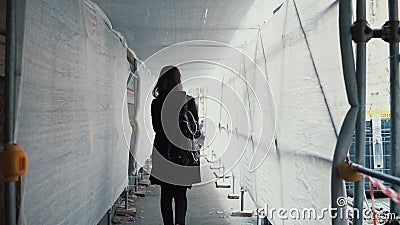 Девушка студента идя через белый коридор конструкции Задний взгляд молодой женщины идет работать через здание сток-видео Девушка студента идя через белый коридор конструкции Задний взгляд молодой женщины идет работать через здание сток-видео