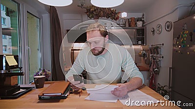 Молодой бизнесмен при документы сидя на таблице, работая с бумагами и проверяя что-то на телефоне сток-видео Молодой бизнесмен при документы сидя на таблице, работая с бумагами и проверяя что-то на телефоне сток-видео