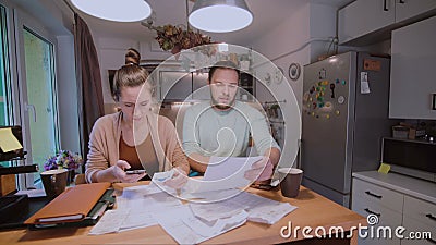 Молодые пары высчитывая их отечественный бюджет совместно в кухне, попытке к безопасным деньгам, имеющ стрессы акции видеоматериалы Молодые пары высчитывая их отечественный бюджет совместно в кухне, попытке к безопасным деньгам, имеющ стрессы акции видеоматериалы
