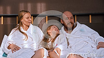 Счастливая семья в белых халатах сидит в постели и разговаривает друг с другом видеоматериал Счастливая семья в белых халатах сидит в постели и разговаривает друг с другом видеоматериал
