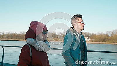 Тысячелетние люди в солнечных очках: друзья молодого человека и женщины идут на набережную сток-видео Тысячелетние люди в солнечных очках: друзья молодого человека и женщины идут на набережную сток-видео